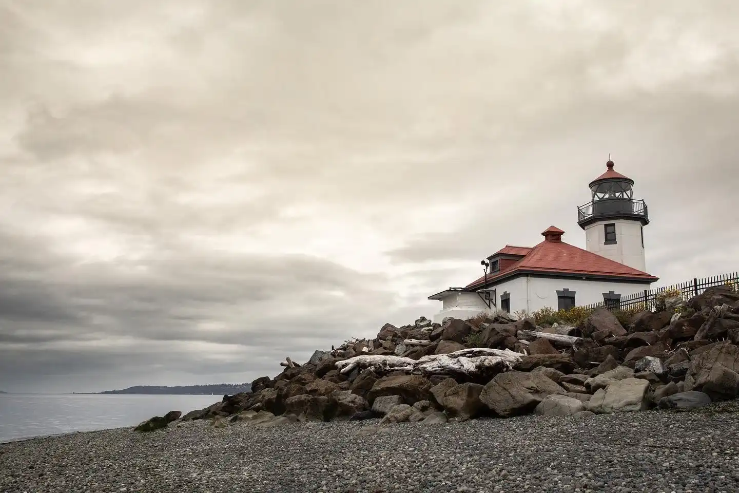Historic Alki Point Lighthouse on a rocky beach, featured in this essential West Seattle Guide.