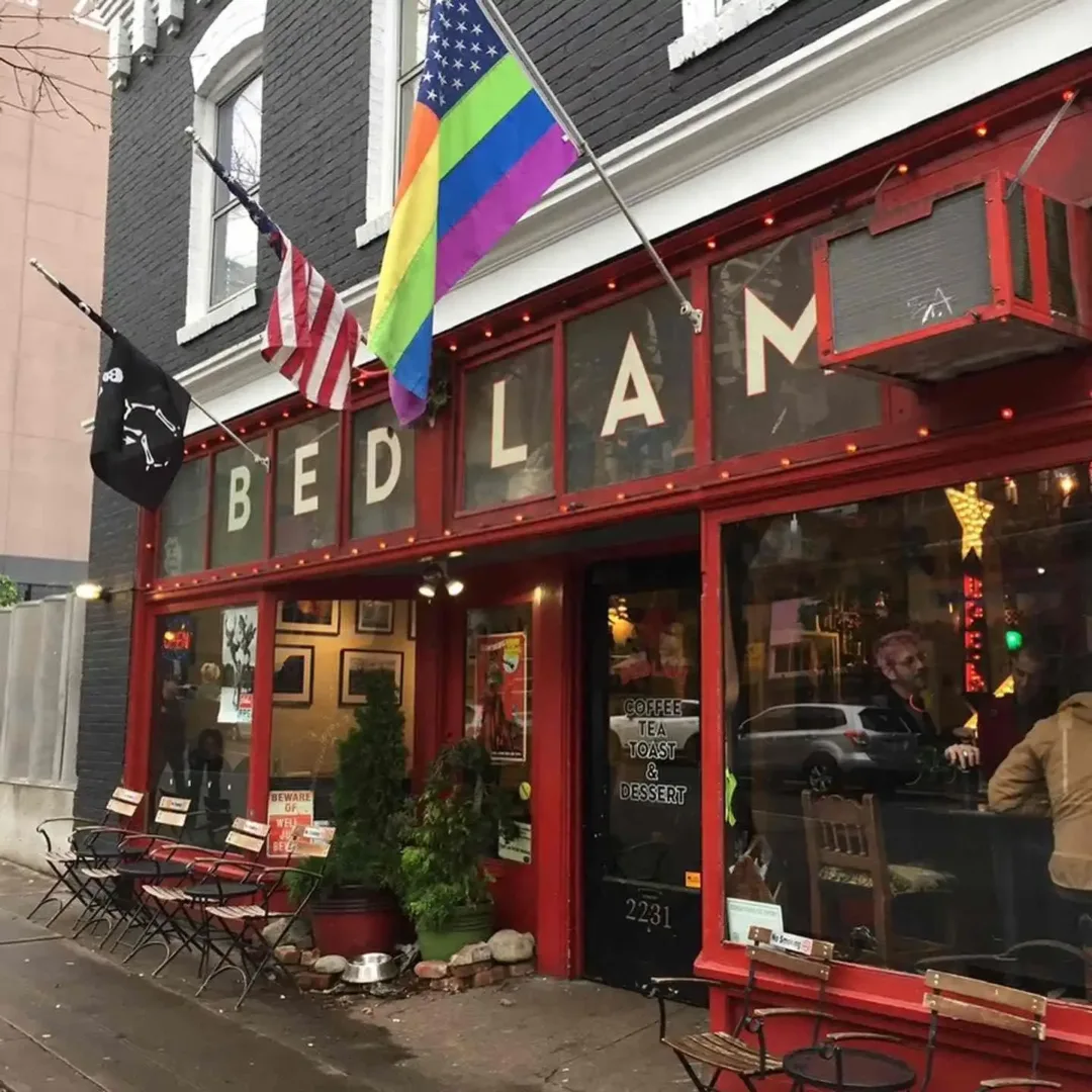 Red storefront of Bedlam Coffee in Belltown Seattle, with flags and outdoor seating visible.