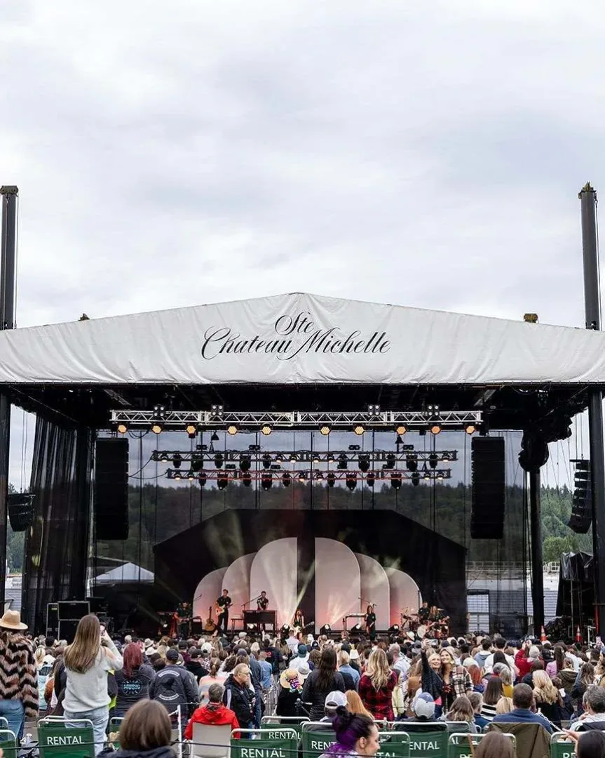 A large outdoor concert crowd watching a performance on stage in Seattle in June.