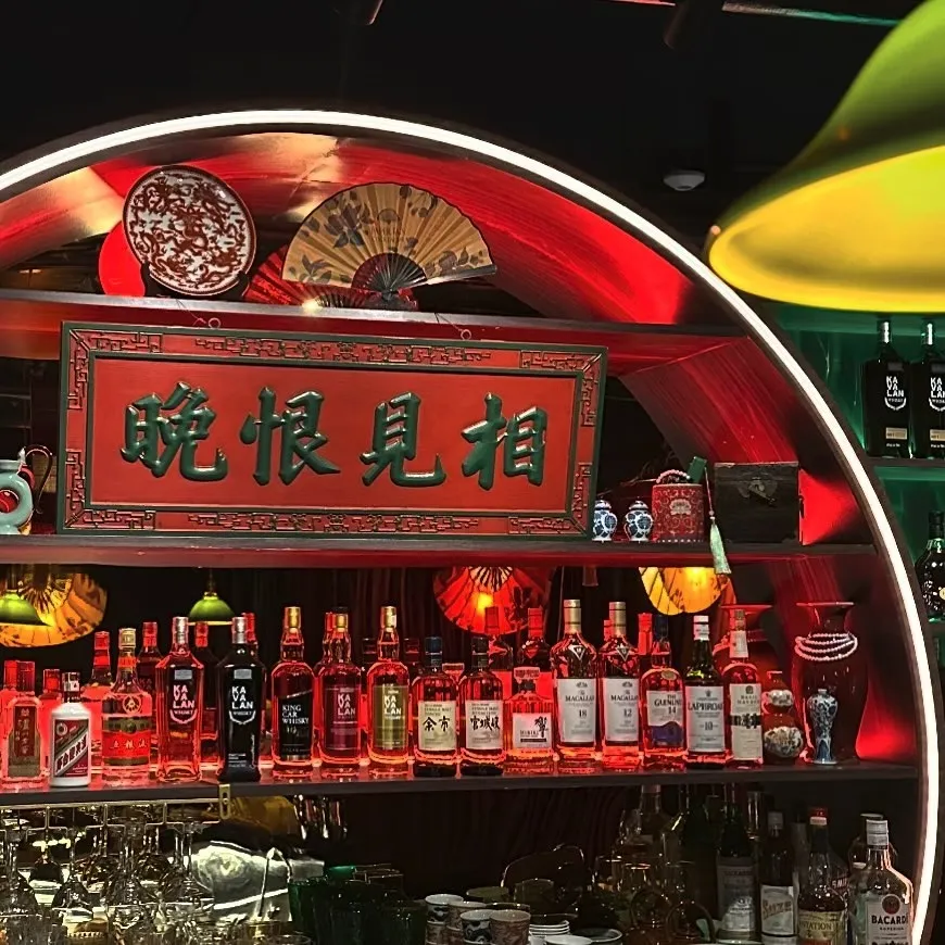 Rows of unique liquor bottles and cultural decor shine at a stylish bar in Capitol Hill Seattle.