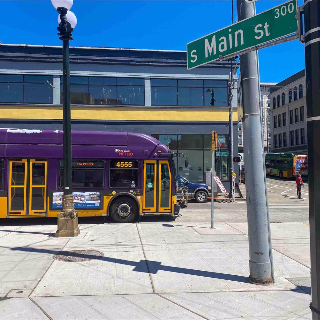 A purple King County Metro bus stops at S Main St, helpful for getting around Seattle.