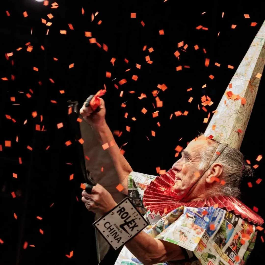 A circus performer in a cone hat is showered with orange confetti at a festival in Seattle in April.
