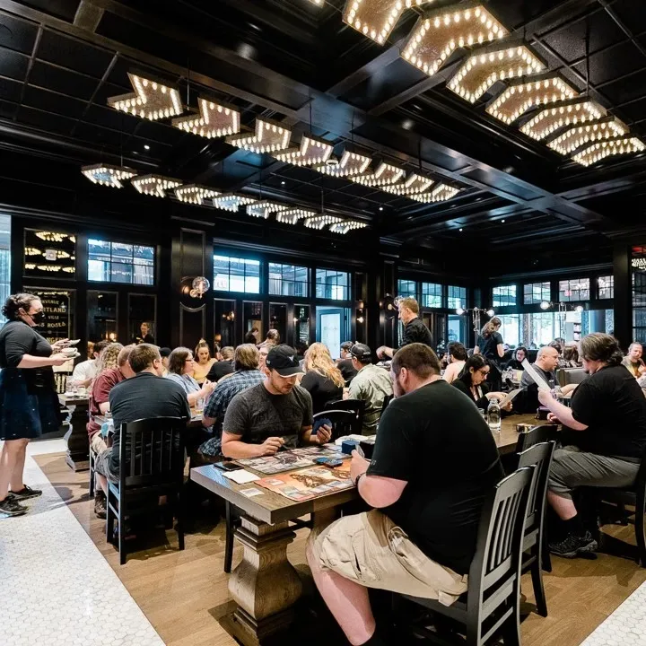 People enjoy playing card games together in the spacious and lively Mox Boarding House Ballard Seattle.
