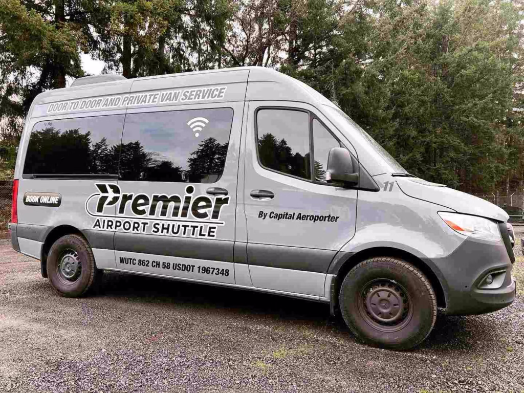 A Premier Airport Shuttle van parked near trees offers a private option for getting around Seattle.