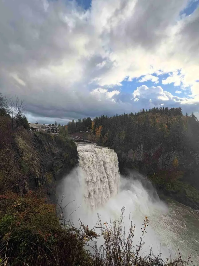 Snoqualmie Falls is a powerful, misty waterfall surrounded by lush forest near Seattle in July.
