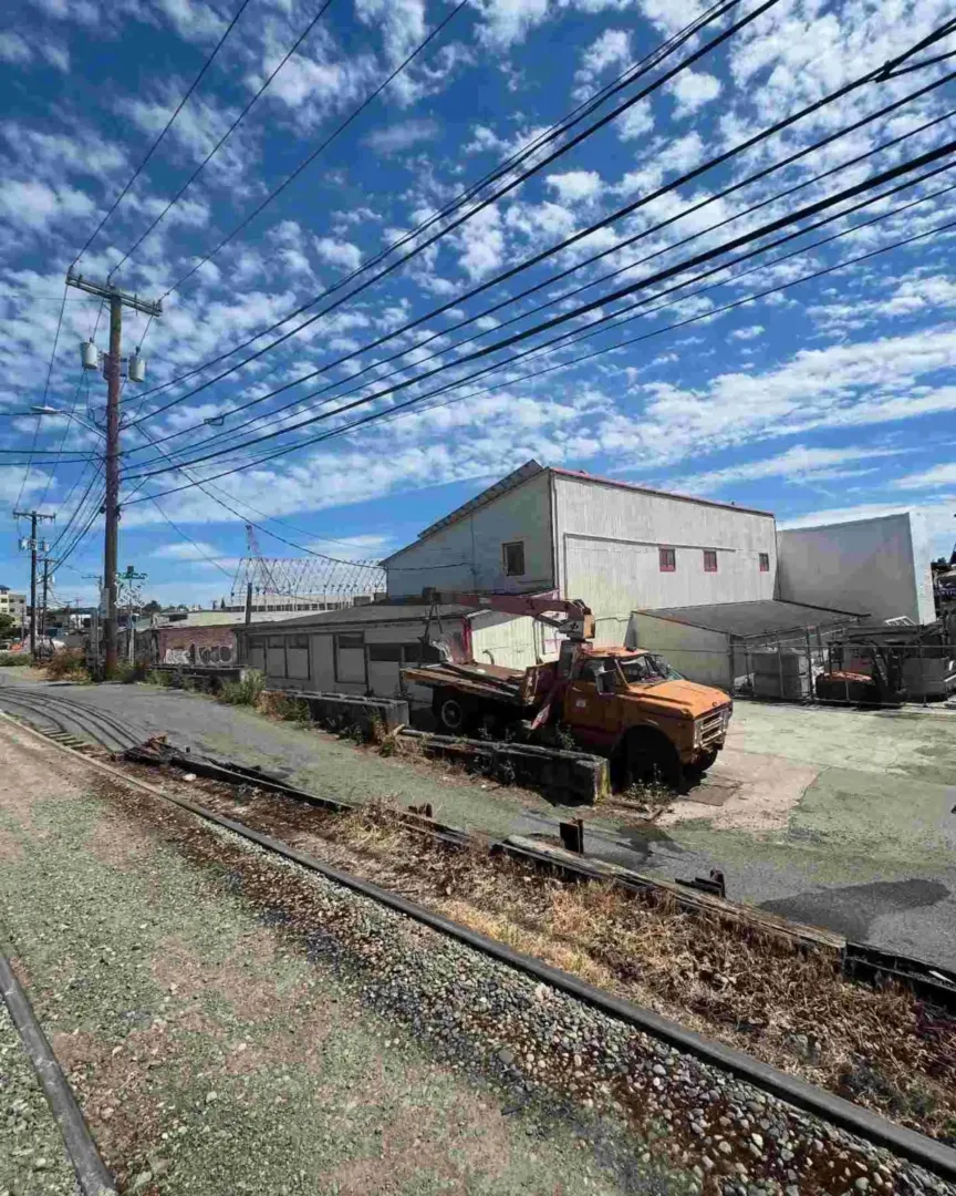 Abandoned railroad tracks and an old truck near warehouses in the Seattle Public Transportation corridor.