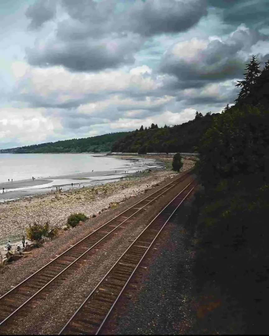 Railway tracks run alongside the rocky shore of Carkeek Park, one of the scenic Seattle beaches.
