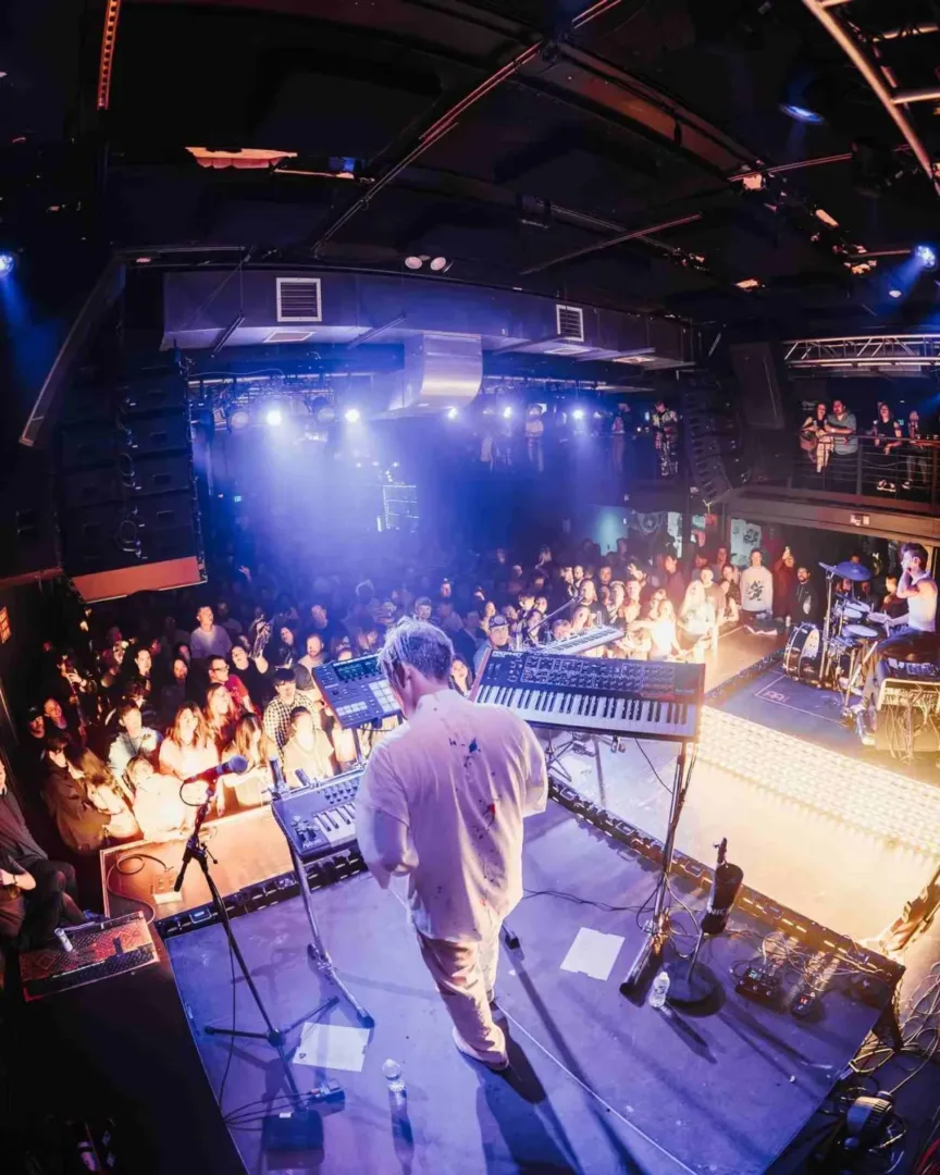 An artist performs on stage for a crowd, highlighting the vibrant Seattle music scene tonight.